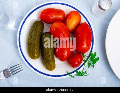 Portion eingelegte Tomaten und Gurken Stockfoto