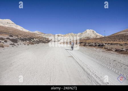 Ein Mann geht entlang einer Bergstraße im Upper Mustang, Himalaya, Nepal Stockfoto