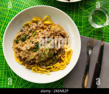 Blick von oben auf Schweineribs mit Pilzsauce und Linguine Stockfoto