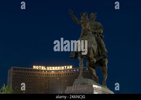 TASCHKENT, USBEKISTAN - 15. SEPTEMBER 2022: Denkmal für Amir Temur (Tamerlane) vor der Kulisse des Hotels Usbekistan am späten Abend Stockfoto