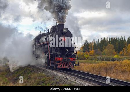 SORTAVALA, RUSSLAND - 09. OKTOBER 2022: Alte sowjetische Dampflokomotive der L-Serie vor dem Hintergrund einer herbstlichen Landschaft an einem bewölkten Oktobertag Stockfoto