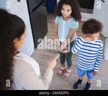 Wenn Mama nein sagt, sollte Papa auch. Eine unkenntliche Frau, die ihre Kinder zu Hause anschreit. Stockfoto