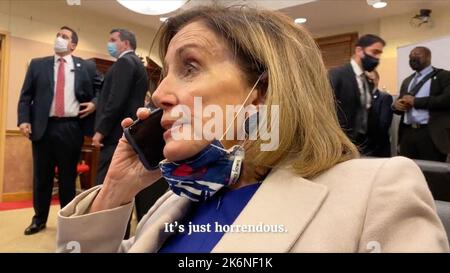 Washington DC, USA. 14. Oktober 2022. House Speaker Nancy Pelosi (D-Calif.) Beobachtet Fernsehberichte über den Angriff, während er mit VA Gov. Ralph Northam.in bisher nicht gesehenen Aufnahmen wird die US-Sprecherin Nancy Pelosi gesehen, die nach mehr Hilfe für das US-Kapitol ruft, da am 6. Januar 2021 Unruhen draußen ausbrechen. Die Aufnahmen wurden während einer Anhörung zu den Unruhen im Januar 6 veröffentlicht und von Pelosi's Tochter, der Dokumentarfilmerin Alexandra Pelosi, gefilmt. Foto von House Jan. 6 Committee/Pool/ABACAPRESS.COM Credit: Abaca Press/Alamy Live News Stockfoto