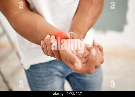 Hier spüre ich den Schmerz. Ein nicht erkennbarer Mann, der Unwohlsein am Handgelenk hat. Stockfoto