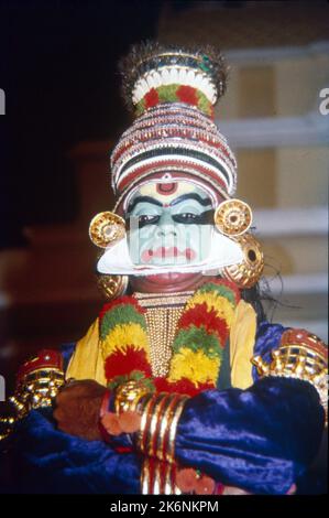 Kathakali:- Indischer klassischer Tanz aus Kerala basiert auf Ramayana, Mahabharata und Geschichten aus der Shaiva-Literatur. Im Freien in einer ganztägigen Funktion singen Stimmen die Geschichten, wie sie von Tänzern nachempfunden werden. Traditionell wird Kathakali von Männern und jungen Jungen, die die Rollen von Männern und Frauen spielen, durchgeführt. Die Gesichter sind so gefertigt, dass sie aussehen wie gemalte Masken, die Kostüme bestehen aus vollem Rock, schwerer Jacke, zahlreichen Girlanden und halslosem und aufragendem Kopfschmuck. Stockfoto