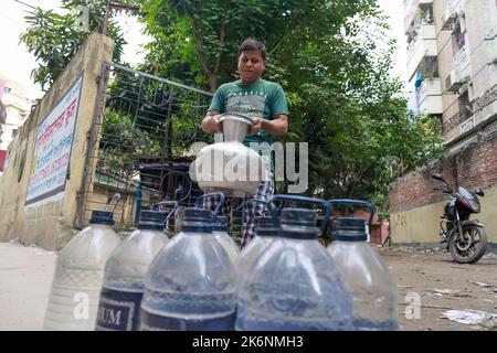 Dhaka, Bangladesch. 14. Oktober 2022. Menschen sammeln Wasser an einem Wasserautomaten in Dhaka, Bangladesch, 14. Oktober 2022. Wasser-Geldautomaten sind bei Stadtbewohnern schnell beliebt, da sie eine gewisse Entspannung vor dem oft kontaminierten Leitungswasser finden. Da die Qualität des Standwassers recht gut ist, wird die Zahl der Nutzer immer größer und macht es für Standbetreiber schwierig, in Spitzenzeiten mit den Nutzern umzugehen. Nutzer sagten, dass das von Dhaka WASA betriebene Frischwasser, das sie von den Ständen erhalten, nicht kontaminiert sei und sie es nicht mehr kochen müssten. Foto von Suvra Kanti das/ABACAPRESS.COM Quelle: Abaca Press/A Stockfoto