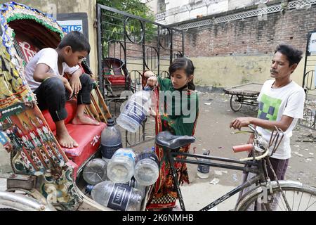 Dhaka, Bangladesch. 14. Oktober 2022. Menschen sammeln Wasser an einem Wasserautomaten in Dhaka, Bangladesch, 14. Oktober 2022. Wasser-Geldautomaten sind bei Stadtbewohnern schnell beliebt, da sie eine gewisse Entspannung vor dem oft kontaminierten Leitungswasser finden. Da die Qualität des Standwassers recht gut ist, wird die Zahl der Nutzer immer größer und macht es für Standbetreiber schwierig, in Spitzenzeiten mit den Nutzern umzugehen. Nutzer sagten, dass das von Dhaka WASA betriebene Frischwasser, das sie von den Ständen erhalten, nicht kontaminiert sei und sie es nicht mehr kochen müssten. Foto von Suvra Kanti das/ABACAPRESS.COM Quelle: Abaca Press/A Stockfoto