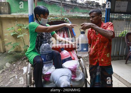 Dhaka, Bangladesch. 14. Oktober 2022. Menschen sammeln Wasser an einem Wasserautomaten in Dhaka, Bangladesch, 14. Oktober 2022. Wasser-Geldautomaten sind bei Stadtbewohnern schnell beliebt, da sie eine gewisse Entspannung vor dem oft kontaminierten Leitungswasser finden. Da die Qualität des Standwassers recht gut ist, wird die Zahl der Nutzer immer größer und macht es für Standbetreiber schwierig, in Spitzenzeiten mit den Nutzern umzugehen. Nutzer sagten, dass das von Dhaka WASA betriebene Frischwasser, das sie von den Ständen erhalten, nicht kontaminiert sei und sie es nicht mehr kochen müssten. Foto von Suvra Kanti das/ABACAPRESS.COM Quelle: Abaca Press/A Stockfoto