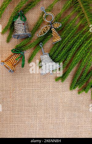 Südafrikanische Perlen-Weihnachtsdekorationen mit Baumstückchen auf rustikalem Quappen-Stoff Stockfoto