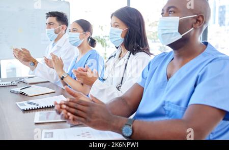 Covid Gesichtsmaske, Klatschen und medizinische Präsentation für Ärzte, Krankenschwestern oder Teamarbeit im Londoner Krankenhaus. Applaus von Männern, Frauen und Medizinern Stockfoto