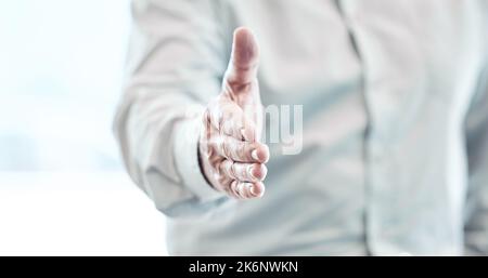 Willkommen im Unternehmen. Ein nicht erkennbarer Geschäftsmann, der in seinem Büro steht und für einen Händedruck gestikelt hat. Stockfoto