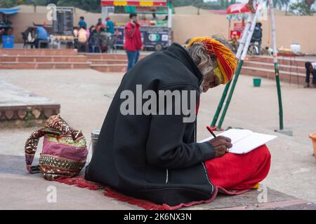 ORCHHA, MADHYA PRADESH, INDIEN - 27. DEZEMBER 2021: Ein Sadhu-Lesebuch in der Nähe des betwa-Flusses. Stockfoto