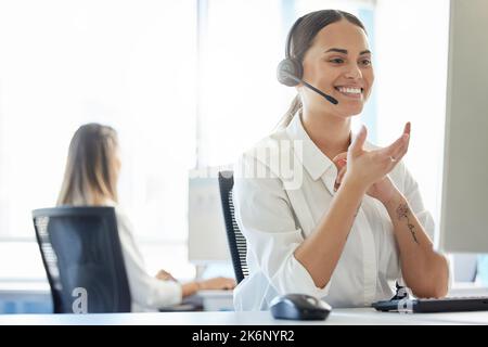 Sagt mir, was Ihr braucht. Eine junge Frau, die ein Headset trägt, während sie in einem Callcenter arbeitet. Stockfoto