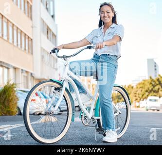 Frau, Fahrrad und Lächeln für Reisen in der Stadt, Straßen eines Studenten entspannen in der Natur. Porträt einer glücklichen asiatischen Frau, die auf dem Fahrrad unterwegs ist Stockfoto