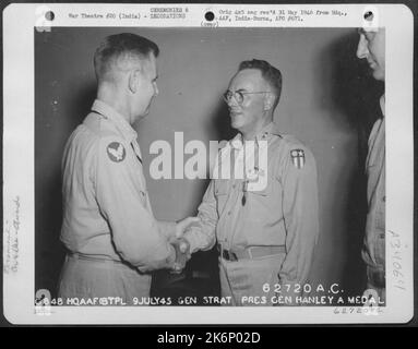 General George E. Stratemeyer gratuliert Generalmajor Thomas J. Hanley, Jr., nachdem er ihm am 9. Juli 1945 auf einer Basis in Indien die Luftmedaille überreicht hatte. Stockfoto