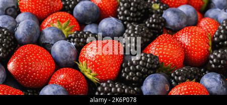 Verschiedene Beeren und Früchte Erdbeeren, Heidelbeeren und Brombeeren Hintergrund Stockfoto