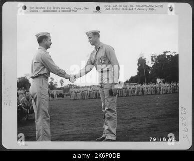 Brig. General Paul B. Wurtsmith, Commander 5. Fighter Command, gratuliert LT. John D. Landers, Joshua, Texas, von der 49. Fighter Group, nachdem er ihm das Purple Heart überreicht hat. Er erhielt auch den Oak Leaf Cluster, Air Medal, Distinguished Stockfoto