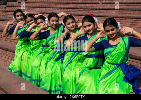 Frauen tragen traditionelle Kleider mit floralen Ornamenten und treten während des Frühlingsfestes auf, dem ersten Frühlingstag des bengalischen Monats ''Falgun''. Stockfoto