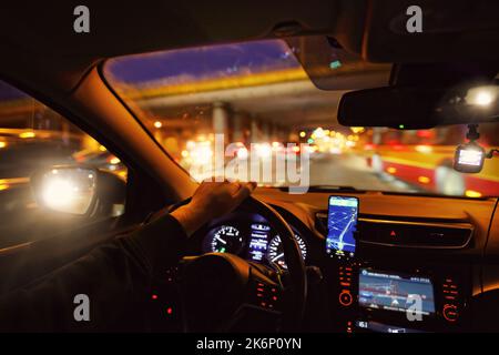 Nachts ein Auto in der Stadt fahren Stockfoto