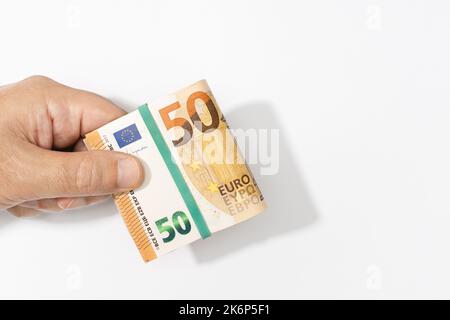 Hand mit gefalteten Euro-Banknoten auf weißem Hintergrund. Speicherplatz kopieren Stockfoto