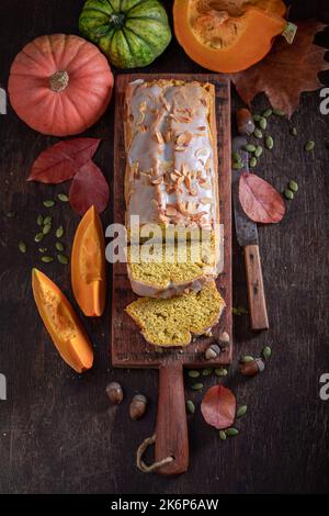 Frischer halloween Kuchen mit Mandeln und weißer Glasur. Herbstkürbisbrot in Scheiben geschnitten. Stockfoto