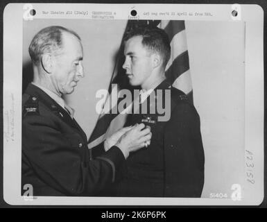 Capt. John J. Brunasky, Sohn von A.F. Brunasky, 1600 Morningside Ave., Pittsburgh, Pennsylvania, wird von Col. John W. Monahan, Stabschef des Generalmajors John F. Cannon's 12. AF, nach Erhalt des Distinguished Flying Cross für seine Heldentaten als gratuliert Stockfoto