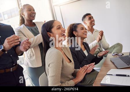 Lachen kann jeden Tag aufhellen. Eine Gruppe von Geschäftsleuten klatscht bei einer Besprechung auf der Arbeit. Stockfoto