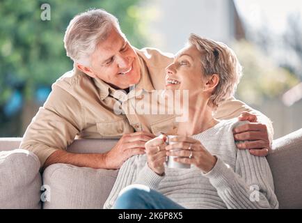 So glücklich, dich in meinem Leben zu haben. Ein glückliches Seniorenpaar genießt zu Hause eine entspannte Kaffeepause auf dem Sofa. Stockfoto