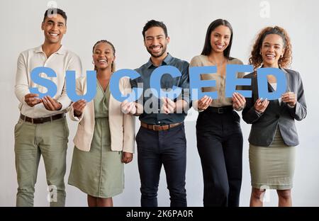 Füttern Sie Ihr Bedürfnis, erfolgreich zu sein. Eine Gruppe junger Geschäftsleute mit Briefen, die das Wort buchstabieren, ist erfolgreich. Stockfoto