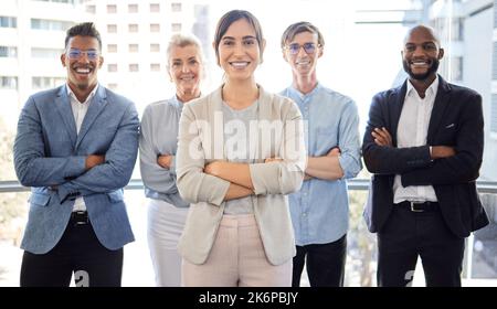 Nichts wird uns davon abhalten, vorwärts zu kommen. Porträt einer Gruppe von Geschäftsleuten, die mit gekreuzten Armen in einem Büro stehen. Stockfoto