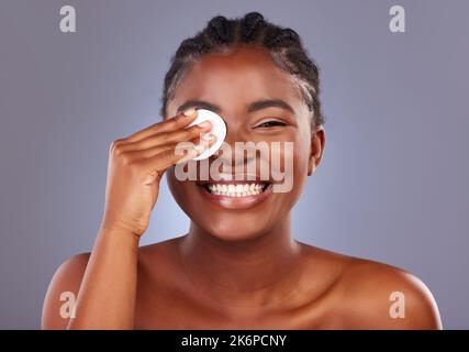 Sie hat eine so schöne Haut. Eine junge Frau, die ihr Gesicht mit einem Wattepad putzt. Stockfoto