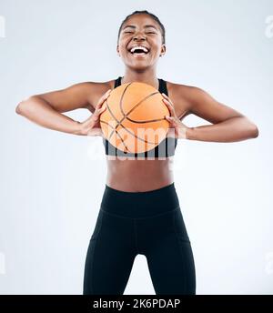 Lasst uns Ball spielen. Studioaufnahme einer sportlichen jungen Frau, die mit einem Basketball vor einem Studiohintergrund posiert. Stockfoto