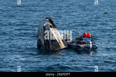 Support-Teams arbeiten um die Raumsonde SpaceX Crew Dragon Freedom, kurz nachdem sie mit den NASA-Astronauten Kjell Lindgren, Robert Hines, Jessica Watkins und der ESA-Astronautin Samantha Cristoforetti an Bord im Atlantik vor der Küste von Jacksonville, Florida, gelandet ist, am Freitag, den 14. Oktober 2022. Lindgren, Hines, Watkins und Cristoforetti kehren nach 170 Tagen im Weltall als Teil der Expeditionen 67 und 68 an Bord der Internationalen Raumstation zurück. Quelle: dpa picture Alliance/Alamy Live News Stockfoto