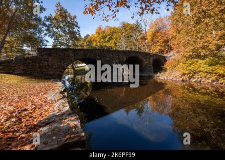 Stone Arch Bridge in Callicoon, NY, Catskill Mountains, umgeben von brillantem Herbstlaub an einem hellen Herbstmorgen Stockfoto