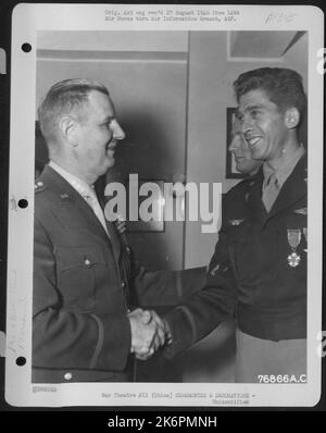 General George E. Stratemeyer gratuliert einem Offizier der Luftwaffe von 14., nachdem er ihm während Einer Zeremonie auf einem Luftwaffenstützpunkt irgendwo in China die Legion of Merit und den Silbernen Stern überreicht hatte. 10. Dezember 1945. Stockfoto