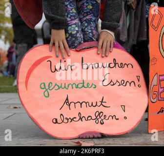 Berlin, Deutschland. 15. Oktober 2022. Ein Kind hält ein Poster mit der Aufschrift „Wir brauchen gesunde Nahrung!“ Bei der Kundgebung der Initiative #ichbinarmutsverraten im Bundeskanzleramt. Armut abschaffen!“. #IchBinArmutsverraten ist ein Hashtag, der seit Mai 2022 im sozialen Netzwerk Twitter verbreitet wird. Von Armut betroffene Menschen berichten über ihre Erfahrungen und Probleme. Quelle: Paul Zinken/dpa/Alamy Live News Stockfoto