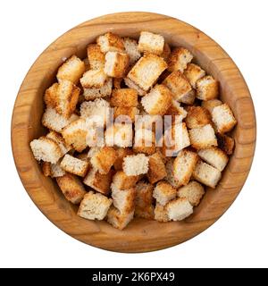 Zwieback. Gebratenes Brot in einer Holzschüssel isoliert auf weißem Hintergrund. Caesar Salat Zutaten. Leckere Snacks. Draufsicht. Datei enthält Stockfoto