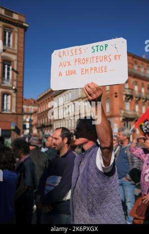 Toulouse, Frankreich. 15. Oktober 2022. Demonstrator mit Plakat gegen Krisenprofiteure. In Toulouse (Frankreich) fand am Vorabend des geplanten marsches in der Hauptstadt am 15. Oktober 2022 eine NUPES-Kundgebung statt. Die verschiedenen linken Parteien ergriffen das Wort, um angesichts der Inflation und der sozialen Ungerechtigkeit Lohn- und Rentenerhöhungen zu fordern und die Entscheidungen der Regierung, die den Klimaherausforderungen entsprechen, zu treffen. Foto von Patrick Batard/ABACAPRESS.COM Quelle: Abaca Press/Alamy Live News Stockfoto