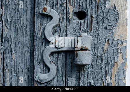 Ländliche Holztür mit einem Metallhaken Minimalismus, Farbe, Geometrie, Linien, Textur, Holz, Dorf, Stadt, Gebäude, Drähte, Dach, Himmel, Gefälle, alt, vinta Stockfoto