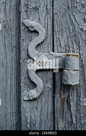 Ländliche Holztür mit einem Metallhaken Minimalismus, Farbe, Geometrie, Linien, Textur, Holz, Dorf, Stadt, Gebäude, Drähte, Dach, Himmel, Gefälle, alt, vinta Stockfoto