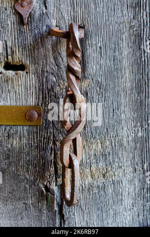 Ländliche Holztür mit einem Metallhaken Minimalismus, Farbe, Geometrie, Linien, Textur, Holz, Dorf, Stadt, Gebäude, Drähte, Dach, Himmel, Gefälle, alt, vinta Stockfoto