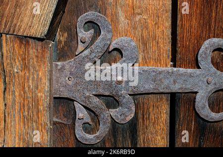 Ländliche Holztür mit einem Metallhaken Minimalismus, Farbe, Geometrie, Linien, Textur, Holz, Dorf, Stadt, Gebäude, Drähte, Dach, Himmel, Gefälle, alt, vinta Stockfoto