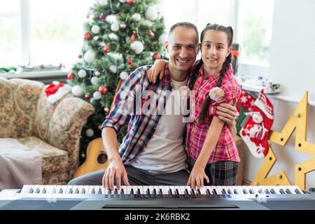 Vater und Tochter spielen zu weihnachten Klavier Stockfoto