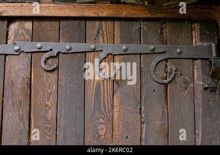Ländliche Holztür mit einem Metallhaken Minimalismus, Farbe, Geometrie, Linien, Textur, Holz, Dorf, Stadt, Gebäude, Drähte, Dach, Himmel, Gefälle, alt, vinta Stockfoto