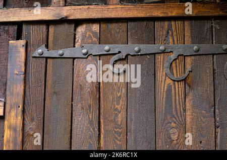 Ländliche Holztür mit einem Metallhaken Minimalismus, Farbe, Geometrie, Linien, Textur, Holz, Dorf, Stadt, Gebäude, Drähte, Dach, Himmel, Gefälle, alt, vinta Stockfoto