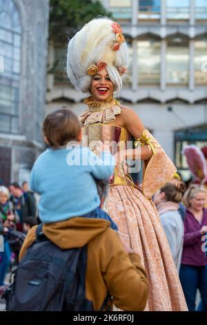 London, Großbritannien. 15. Oktober 2022. Ein Stelzenläufer vom Chivaree Circus nimmt nur einen Tag lang an der Golden Key Teil, einer Kunst-Extravaganz in der Square Mile. Über 200 Künstler, die von der mit dem BAFTA Award ausgezeichneten Wohltätigkeitsorganisation CONEY produziert wurden, bringen immersive Theater-, Akrobatik-, zeitgenössische Tanz-, Musik- und Zirkusvorstellungen zu den berühmtesten Wahrzeichen der Stadt, darunter Guildhall, St Paul’s Cathedral und London High Walks. Kredit: Stephen Chung / Alamy Live Nachrichten Stockfoto