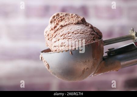 Pflücken Sie Eis mit einem Löffel aus einer Schüssel Stockfoto