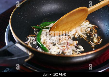 Zwiebel auf Pflanzenöl in die Pfanne geben. Stockfoto