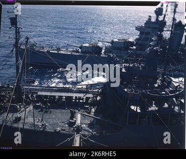 USS Minneapolis (CA-36) Betanken auf See von einem Navy Oiler während der Marshall Islands Operation "Aktivitäten, die von der USS Cowpens (CVL 25) während des Überfalls auf den Marshall und Gilbert Inseln fotografiert wurden. November - Dezember 1943. Die USS Minneapolis (CA 36) wird auf See betankt.“ Stockfoto