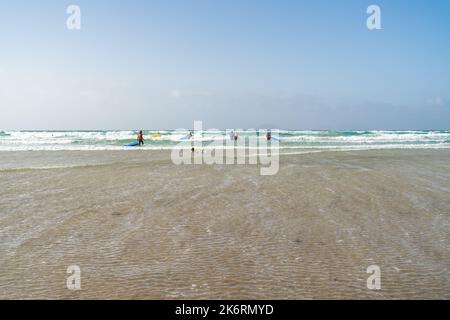 FAMARA BEACH LANZAROTE, KANARISCHE INSELN - 21. JULI 2022: Surfer auf den Wellen. Famara Beach (Playa de Famara), beliebter Surfstrand auf Lanzarote. Stockfoto